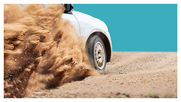 image of a truck driving up a sand dune with sand shooting behind